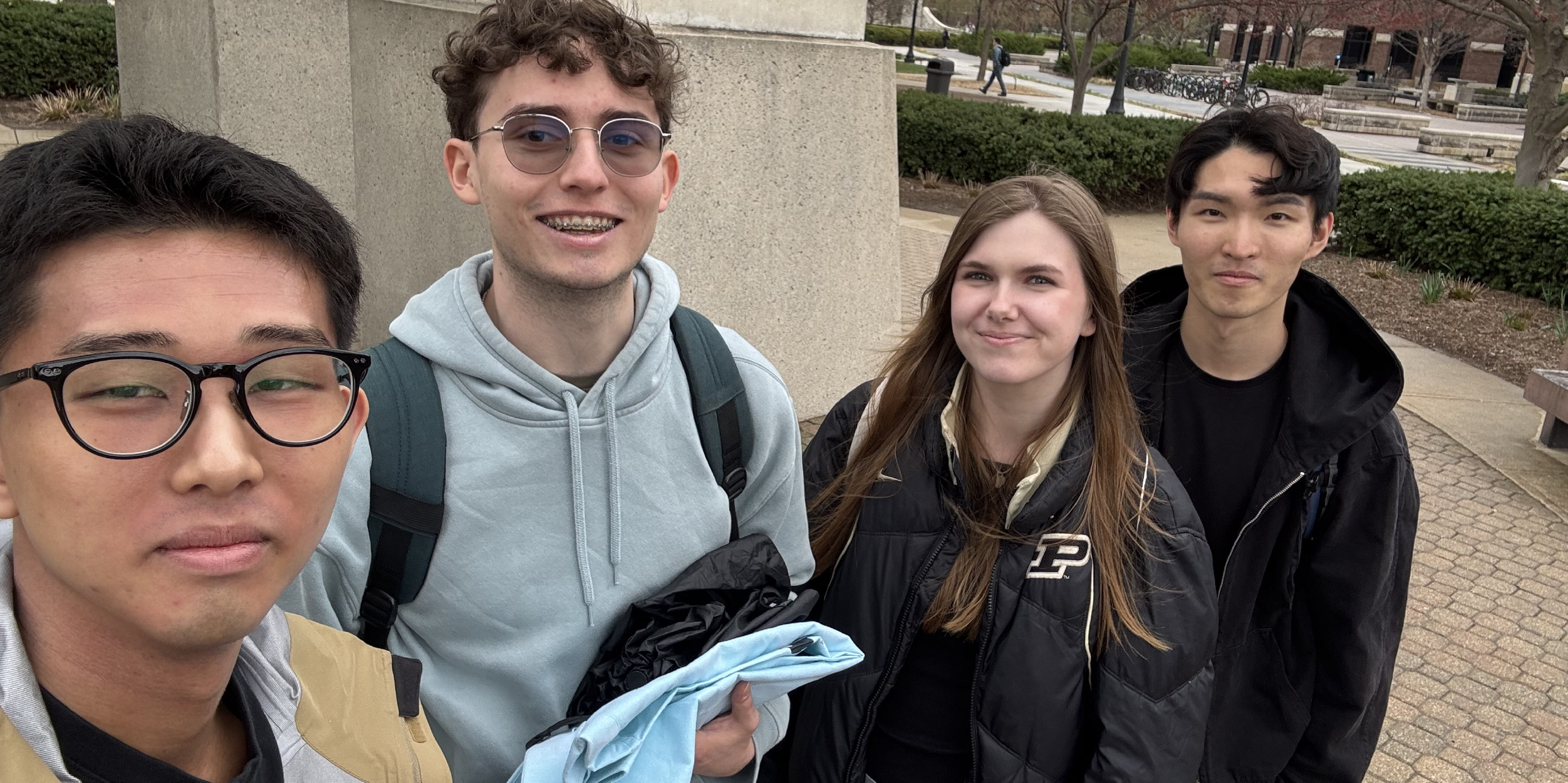 Daniel Park, Emma Mahan, Keisuke Nakamura, and Liam Stonestreet standing outside on the campus of Purdue University